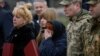 Ukrainian soldiers and relatives of fallen defenders react as they attend a ceremony to mark the first anniversary of the liberation of the town of Bucha on March 31.