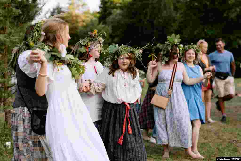 Пришедшие на праздник люди, некоторые в национальной одежде, исполняют танец на поляне.&nbsp; В Беларуси день Ивана Купалы отмечают в ночь на 7 июля