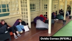 Studenţi la relaxare, pe fololiile din grădina facultăţii.