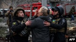A woman reacts in front of a partially destroyed residential building after an air strike in Slovyansk on April 14.