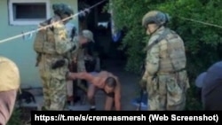 Eski Qırımda qırımlı Dlâver Salimovnı tutalar. «Krımskiy SMERŞ» Telegram kanalı derc etken videodan, 2023 senesi avgust ayı