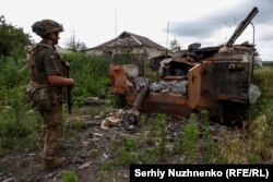 Украинский военный рядом с уничтоженной российской техникой в освобожденном селе Благодатное, Запорожская область, 17 июня 2023 года