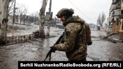 Воїн ЗСУ прочісує вулицю Бахмута