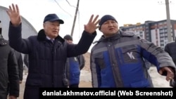 Чыгыш Казакстан облусунун акими Даниал Ахметов (солдо) жана ишкер Айдос Бактыбаев Өскеменде салынып аткан үйлөрдү аралап жүрөт.
