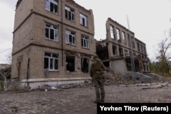 Поліцейський стоїть перед пошкодженою будівлею під час нападу Росії на Україну в місті Авдіївка, Донецька область, Україна, 17 жовтня 2023 року. REUTERS / Євген Тітов