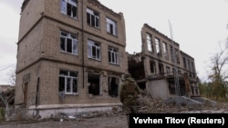 Поліцейський стоїть перед пошкодженою обстрілами будівлею в Авдіївці, 17 жовтня 2023 року