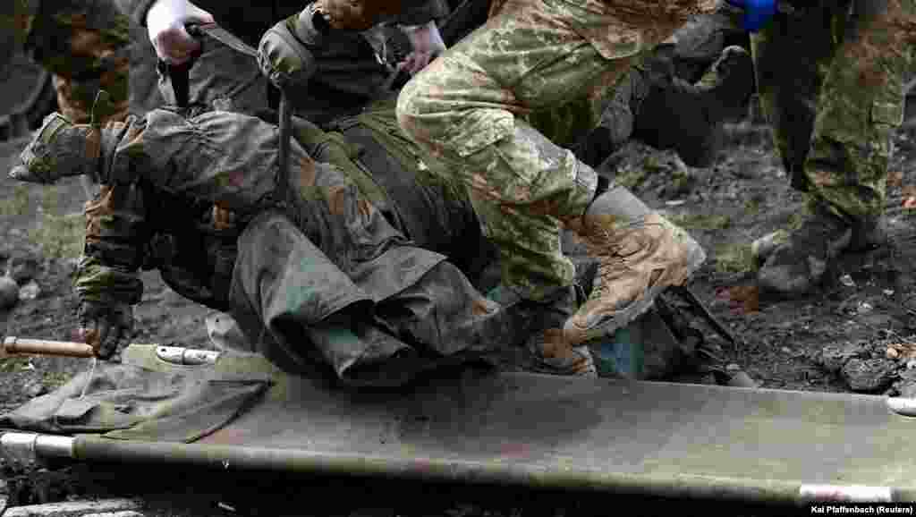 The body of another dead Ukrainian soldier is removed near the front line in Bakhmut.