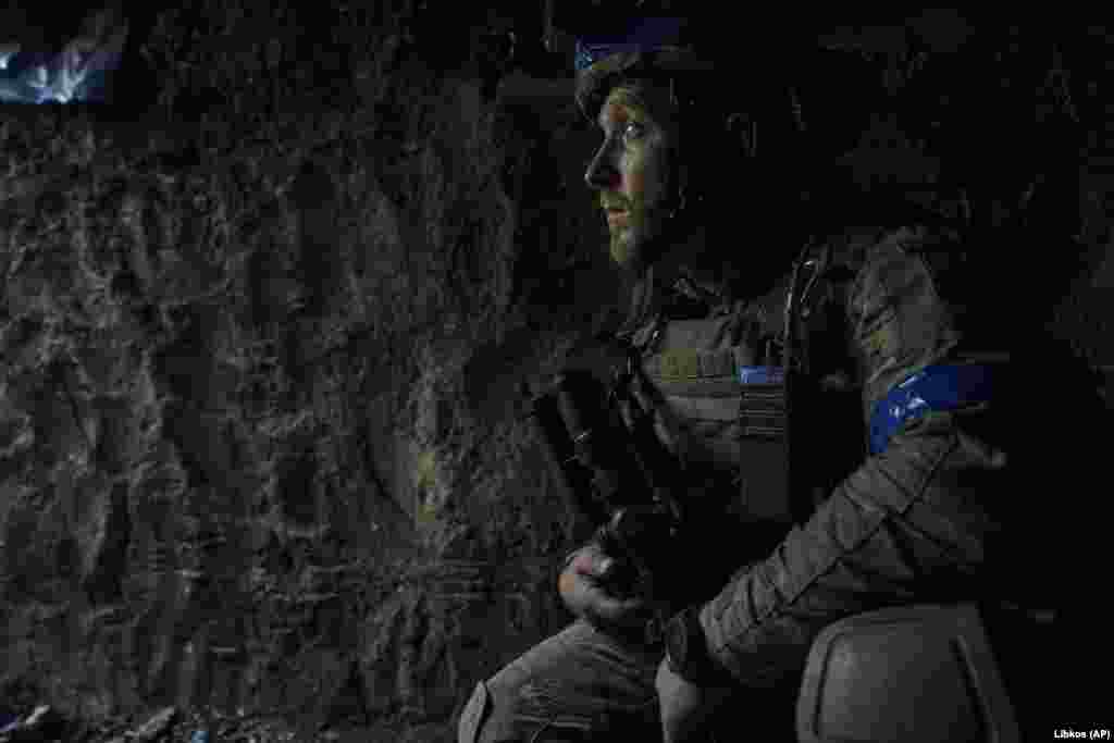 Боєць ЗСУ виглядає зі своєї траншеї