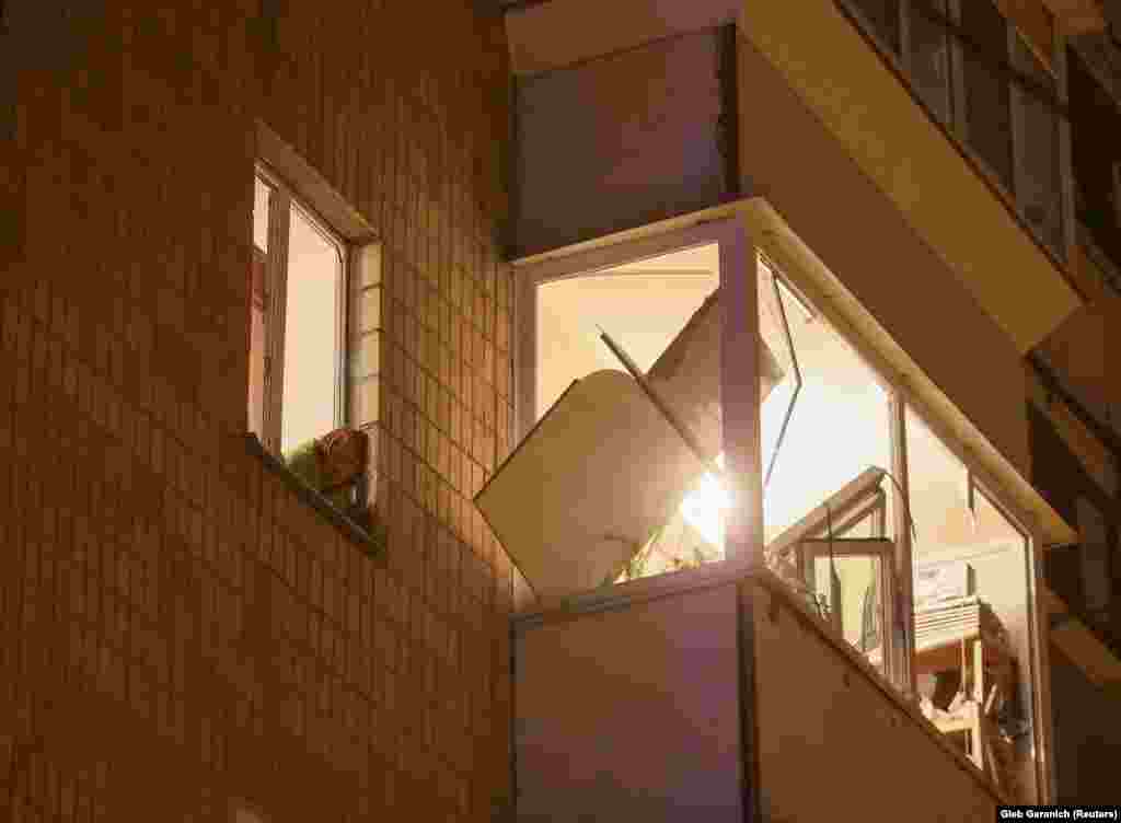 Жительница выглядывает из окна повреждённой квартиры. По словам Попко, люди получили травмы в основном от разбитых взрывной волной окон. Он предположил, что число раненых может возрасти&nbsp;