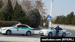 Polisiýanyň ýol gözegçiligi gullugynyň işgäri we hususy ulagdaky raýat (Illýustrasiýa suraty)