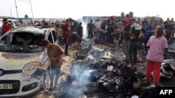 Палестинці збираються на місці ізраїльського удару по табору для внутрішньо переміщених осіб у Рафаху 27 травня