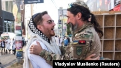 Український військовослужбовець із позивним «Раббі» обіймається із єврейським паломником під час святкування свята Рош га-Шана, єврейського Нового року. Умань, 16 вересня. 2023 року
