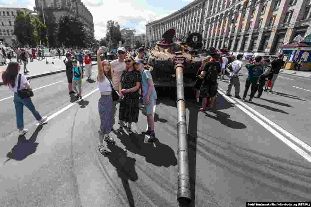 Люди фотографуються біля знищеної російської техніки. Майдан Незалежності. Київ, 24 серпня 2023 року