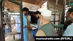 Торхам чек ара пунктунан өтүп жаткан жарандар. 