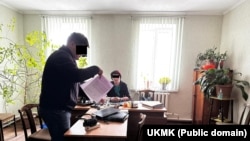 Чолпон-Ата шаарындагы "Жетиген" базарынын директорунун иш бөлмөсүн тинтүү маалы. УКМК тараткан сүрөт.