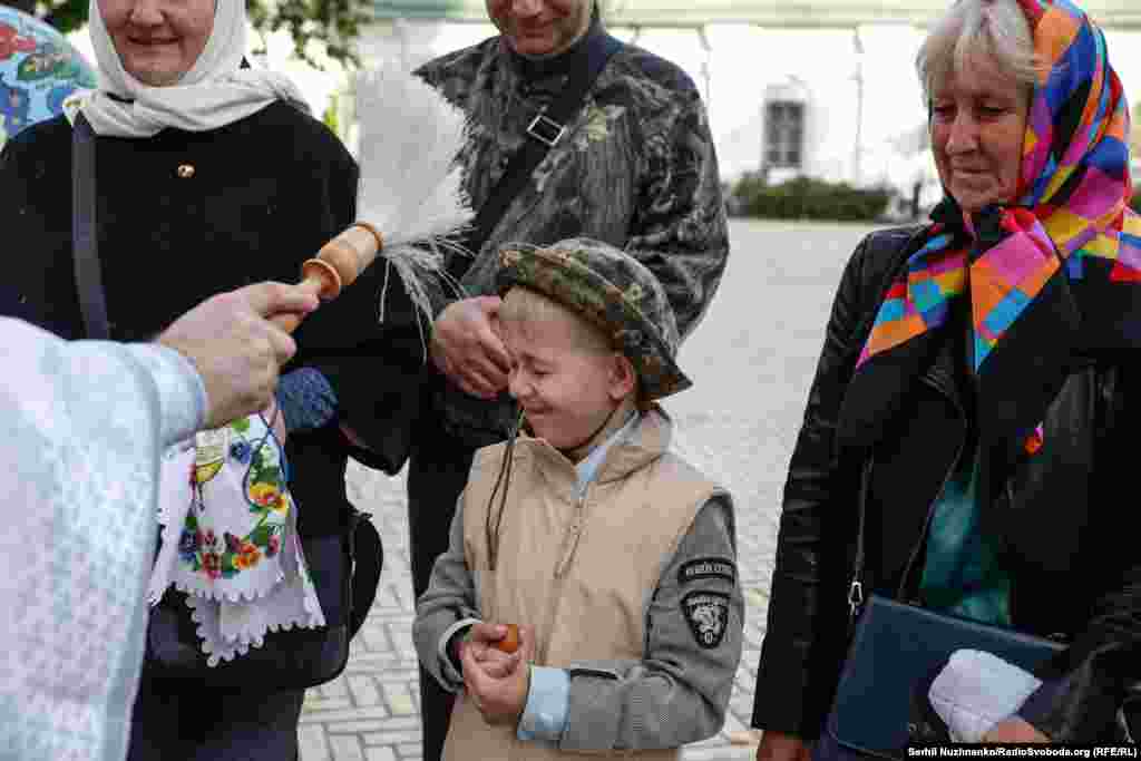 Священник не шкодує освяченої води і щедро кропить не тільки великодні кошики, але й усіх вірян