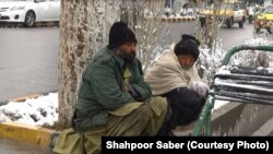 دو کارگر روزمزد در انتظار پیدا شدن کاری در گوشه‌ای از شهر هرات در یک روز سرد زمستان نشسته اند. 