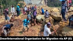 Жергиликтүү тургундар жер көчкүнүн алдынан жакындарын издеп жатышат. 26-май, 2024-жыл. Папуа-Жаңы Гвинея.