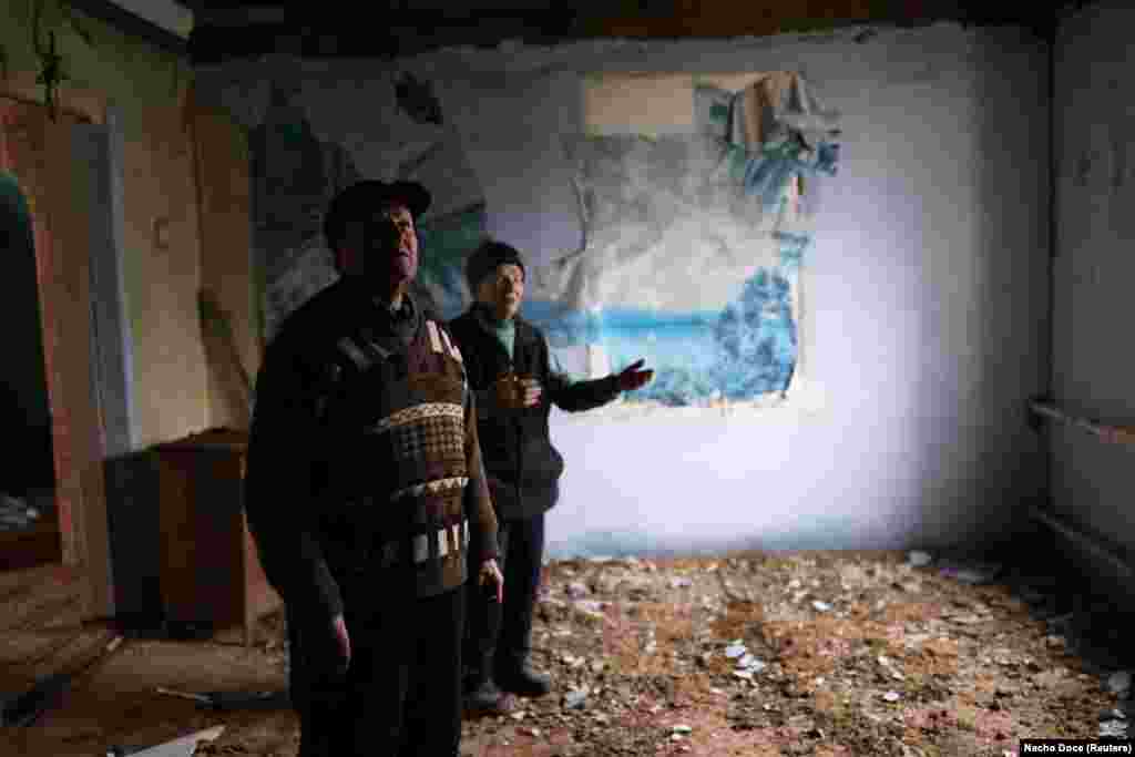 Stepan and Tetyana stand inside their war-damaged home. Many of the buildings in the small village, which had an estimated 2,300 people, were destroyed during the fighting. &quot;We are 80, we&rsquo;ve worked all our lives in the same garden, and now we&rsquo;re waiting for death,&quot; Stepan said. &nbsp;