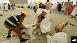 کارکنان بخش امداد صحی یک حاجی را که در جریان مراسم حج بیمار شده است، از روی جاده بر میدارند