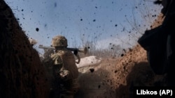 A Ukrainian soldier fires a grenade launcher on the front line during a battle with Russian troops near Bakhmut on March 24.