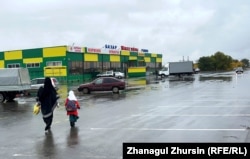 Көшеде кетіп бара жатқан ниқаб киген әйел мен орамал тартқан оқушы қыз. Ақтөбе қаласы Жібек жолы ықшамауданы, 6 қазан, 2023 жыл.