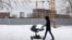 A man pushes a stroller near a residential building site in northern Moscow. (file photo)