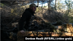 Військовослужбовець ЗСУ маскує гармату М777 у Херсонській області