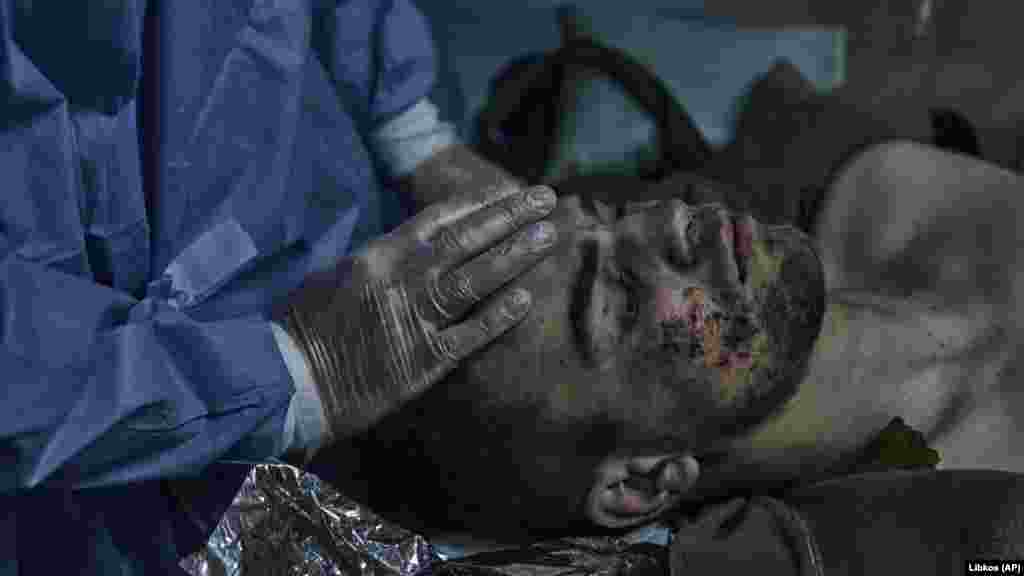 A military medic gives first aid to an injured soldier.