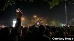 A Bishkek police official tries to calm protesters near a dorm for foreign students in the Kyrgyz capital on the night of May 17-18.