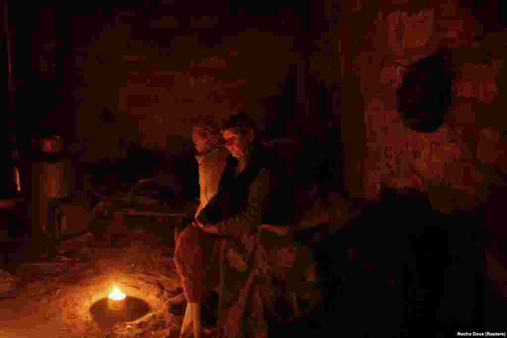 Lit by candles, the cellar her late son Oleksandr had built as a food store is now their home. &nbsp;