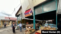 Ստեփանակերտցիները վաճառվող բանջարեղենի կողքով են անցնում: Տեղական արտադրանքը վաճառվում է նախկինից մի քանի անգամ ավելի թանկ, ինչը շատերի համար անհասանելի է։ Լուսանկարը՝ հուլիսի 18-ի։