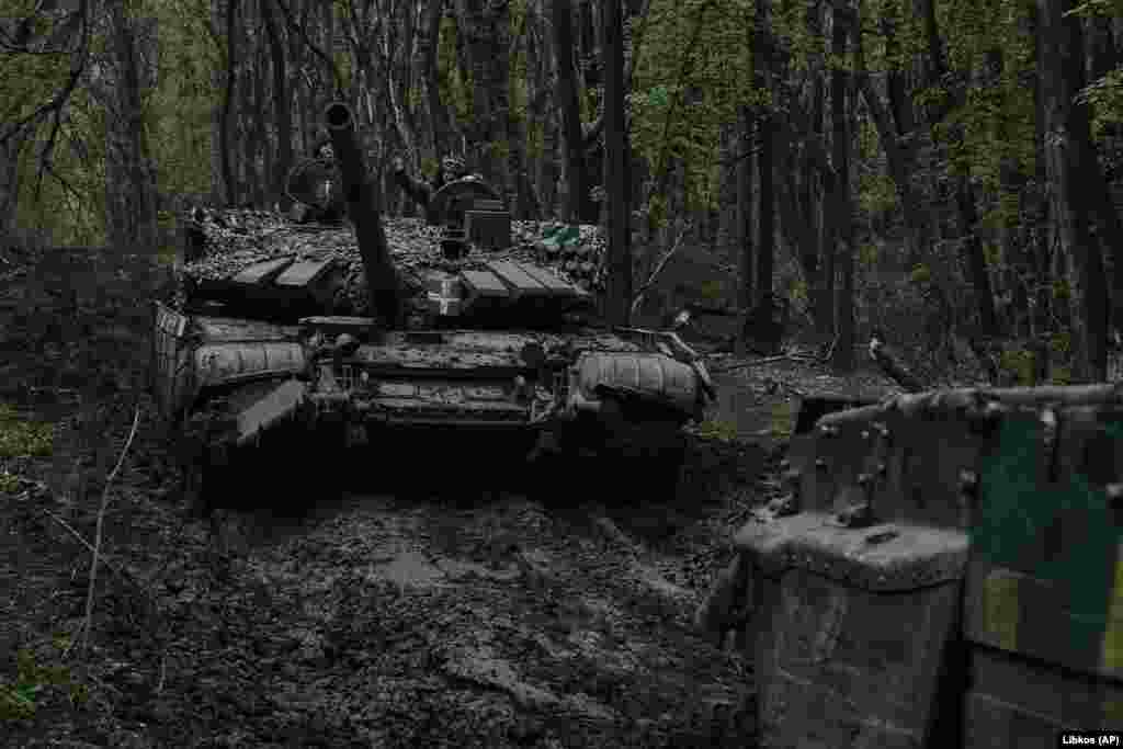 Ukrainian soldiers wave atop a passing tank on the front line in Bakhmut on April 23. Kyiv&#39;s fighters are still able to resupply its troops into the beleaguered city despite brutal combat that has resulted in high casualties on both sides. &nbsp;
