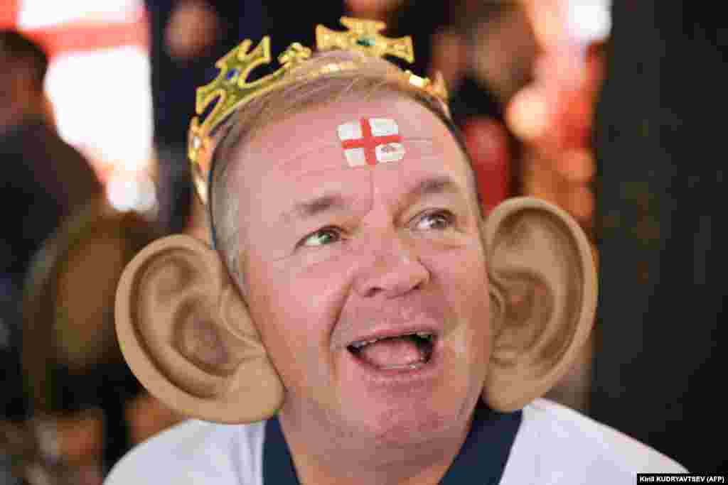 Поддерживающий сборную Англии мужчина в короне и с гигантскими накладными ушами в районе главного вокзала Франкфурта-на-Майне. 20 июня 2024 года. В этот день состоялся матч в группе C между Данией и Англией. Результат встречи оказался 1:1