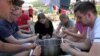 Young people from the Netherlands cook their meal together in the village of Vahagni, Lori Province, Armenia, where they are spending their summer vacation volunteering. 