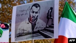 Türkiyədə insanlar İranda həbs olunan iranlı reper Tumac Salehinin portretləri olan plakatlar tuturlar.