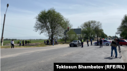 Дмитриевка айылына кирчү жолду тосуп турган милиция кызматкерлери.