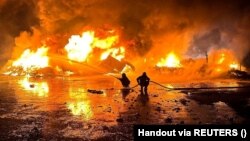 Ukrain ýagyn söndürijileri Russiýanyň Danube portuna uran zarbasynyň netijesinde dörän ýangyny söndürýärler.