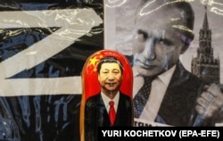 Російська матрьошка з портретом голови Китаю Сі Цзіньпіна перед фотографією очільника Росії Володимира Путіна у сувенірній вуличній крамниці в центрі Москви, 20 березня 2023 року (ілюстраційна світлина)