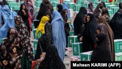 Ооган аялдары гуманитардык жардам алып жаткан учур.  Герат, 21-июнь, 2023-жыл.