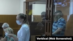 Ігар Кляўко (на здымку з барадой, за шклом у клетцы) на кожным пасяджэньні суду заяўляў аб сваёй невінаватасьці і незаконным утрыманьні пад вартай. Так ён выглядаў у ліпені 2021-га