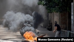 Жениндеги операция маалында палестиналык жигит израилдик аскерлерге таш ыргытып жатат. 4-июль, 2023-жыл. 
