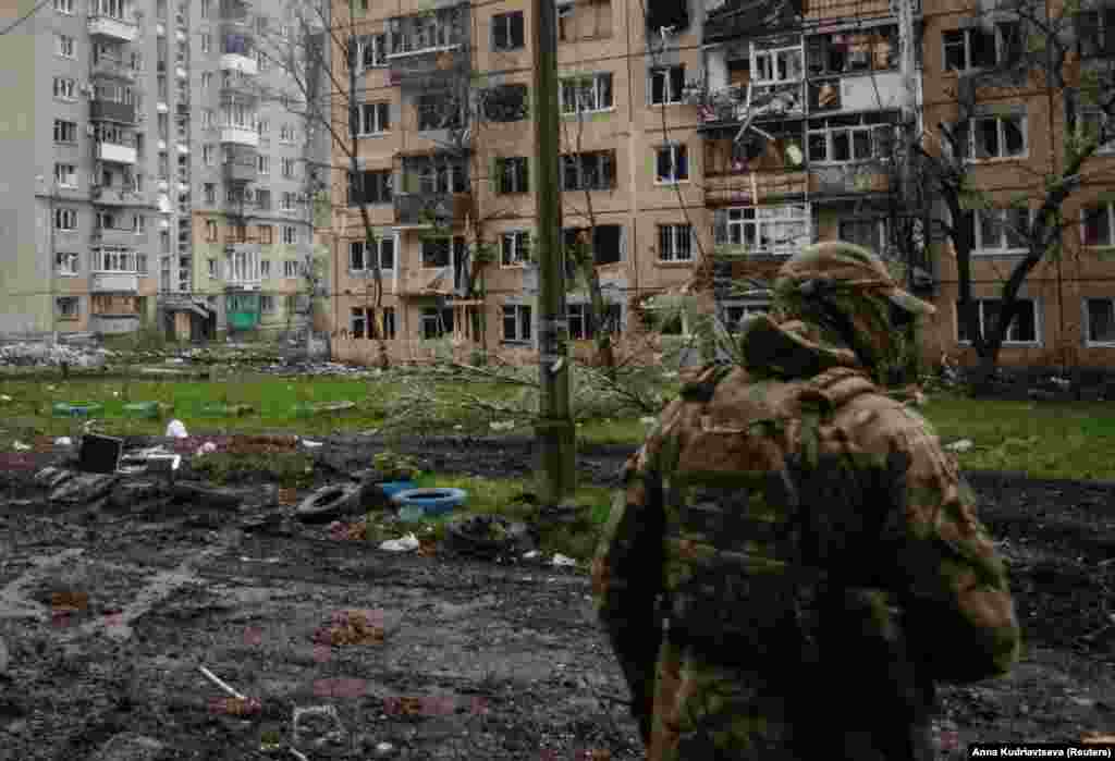 A Ukrainian soldier on patrol near damaged residential buildings in Bakhmut. Syrskiy&#39;s comments came after Russia&#39;s Defense Ministry said on April 23 that its forces had captured two districts in the western part of the city.&nbsp;The claim could not be independently verified.
