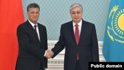 The demonstration and detentions in Almaty took place as Kazakh President Qasym-Zhomart Toqaev (right) met in Astana with Ma Xingrui (left), the Communist Party secretary in Xinjiang, on March 27.