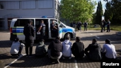 Germaniýa-Polşa serhedinde nemes polisiýasy tarapyndan saklanan bikanun migrantlar. Illýustrasiýa suraty. Arhiwden alyndy.