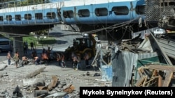 Komunal işçiler rus harby zarbasynda weýran bolan ýeri arassalaýarlar. Dnepr, Ukraina. 24-nji awgust, 2023