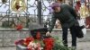 A woman lays flowers at a memorial near the train station in Kramatorsk in Ukraine's Donetsk region where dozens of civilians were killed by a Russian missile strike one year ago. 