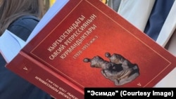 "Ысымдарын кайтаруу" акциясынын катышуучусу репрессия курмандыктарынын тизмесин окуп жатат. Бишкек, Горький паркы, 29-октябрь, 2023-жыл.