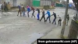 4 березня 2022 року. Кадр із камери відеоспостереження: російські солдати ведуть 9 людей під дулами автоматів у свій штаб в окупованій Бучі. Після катувань їх стратять. 