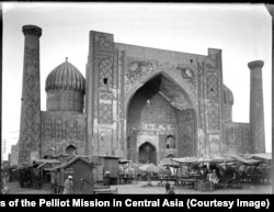 Самарканддын тарыхый борбору - Регистан аянты. Аянтта соодагерлер күркөлөрү менен турушат. Коргондун астындагы имарат - Шердор медресеси